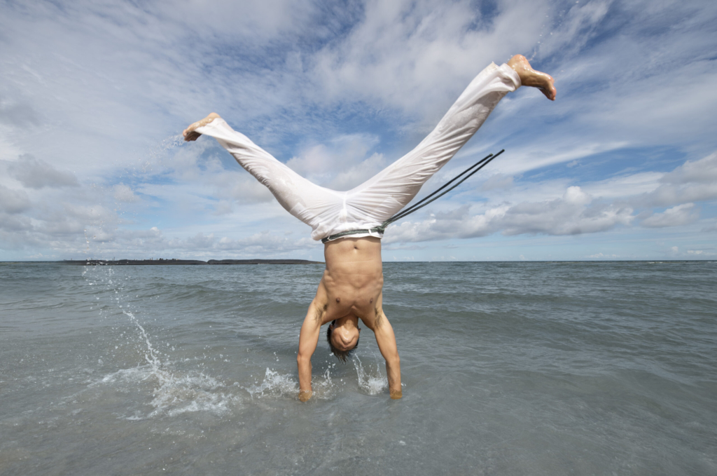man-training-capoeira-beach